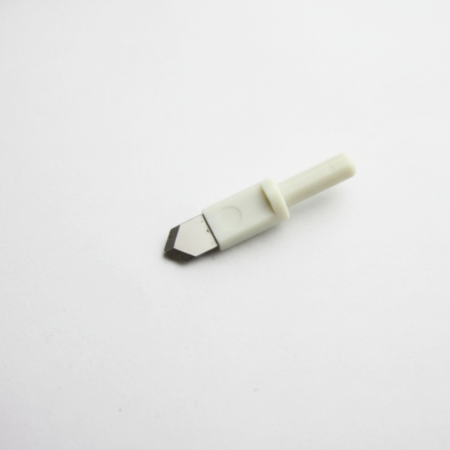 Macro shot showcasing the sharp steel point of an adjustable rotary circle trimmer replacement blade head.