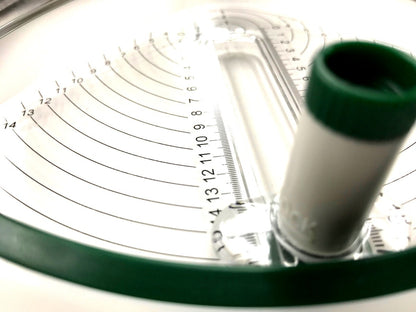 Close-up of a circular measuring device with a green rim and white central part.