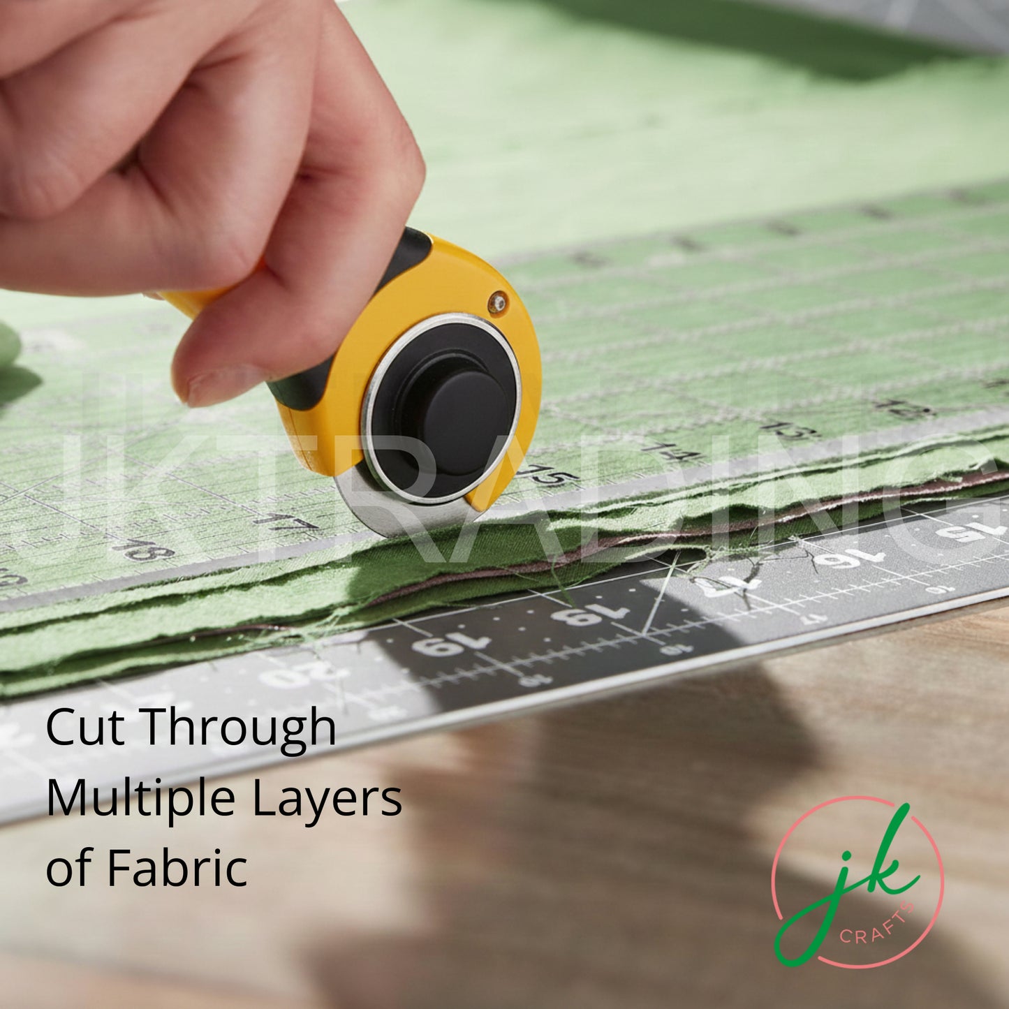 Crafter pushing a rolling rotary fabric cutter along an acrylic patchwork ruler to trim textured green cloth.