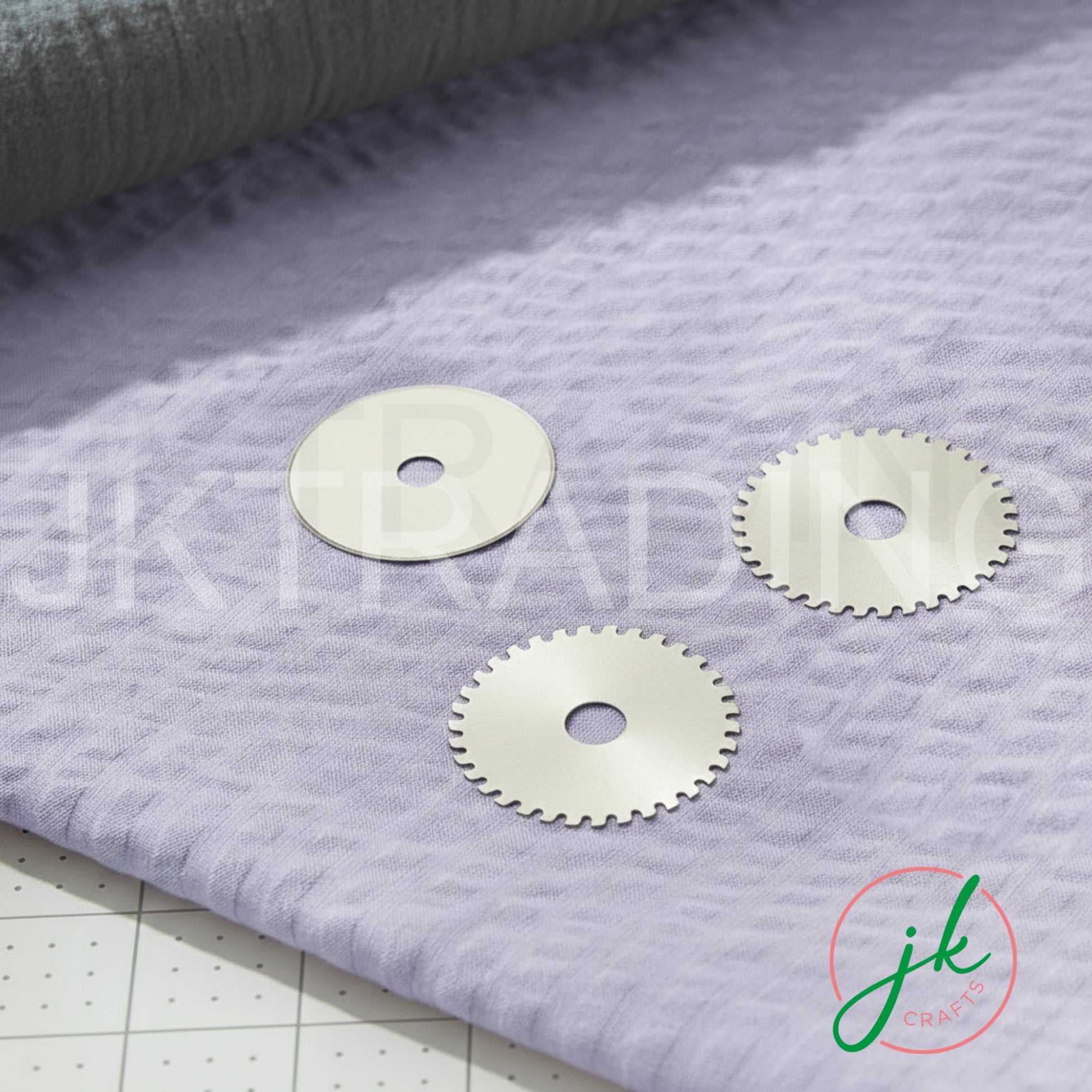 Three steel rotary cutter replacement discs arranged flat on a textured purple wool background.
