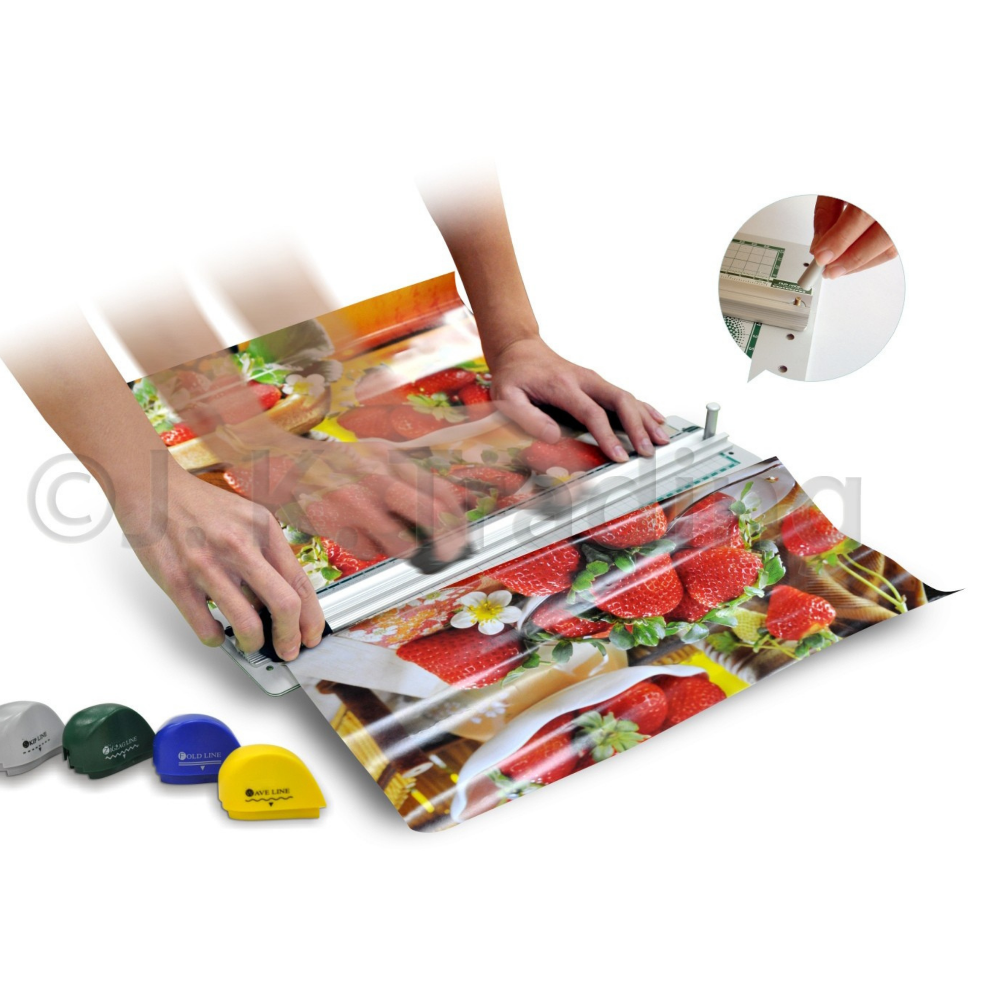 Hands operating a desktop multi-blade rotary paper trimmer system to slice and score colorful holiday gift wrapping paper.