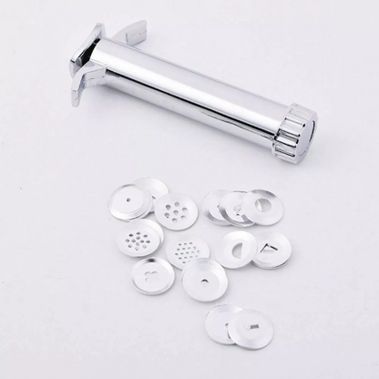 Polished metal icing and sculpting gun kit surrounding by its circular interchangeable steel pattern washers.