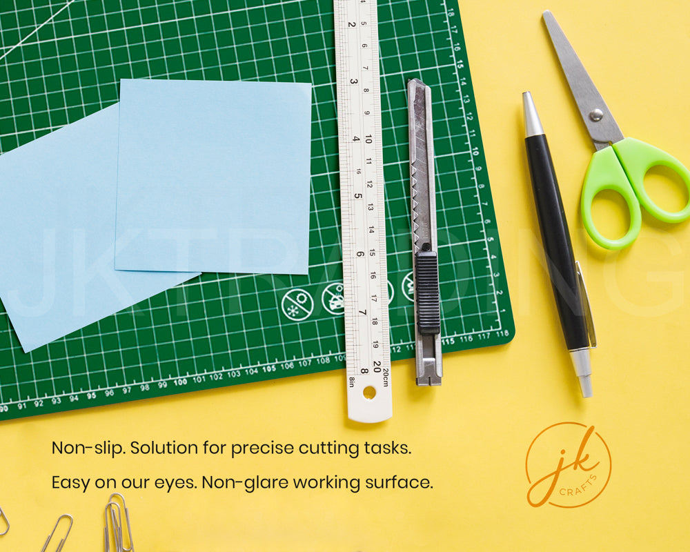Crafting tools including scissors, ruler, and knife on a green cutting mat with text about non-slip surface.