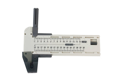T-shaped edge-guided rotary paper slicer tool mechanism shown on a clear plastic measuring guide track.