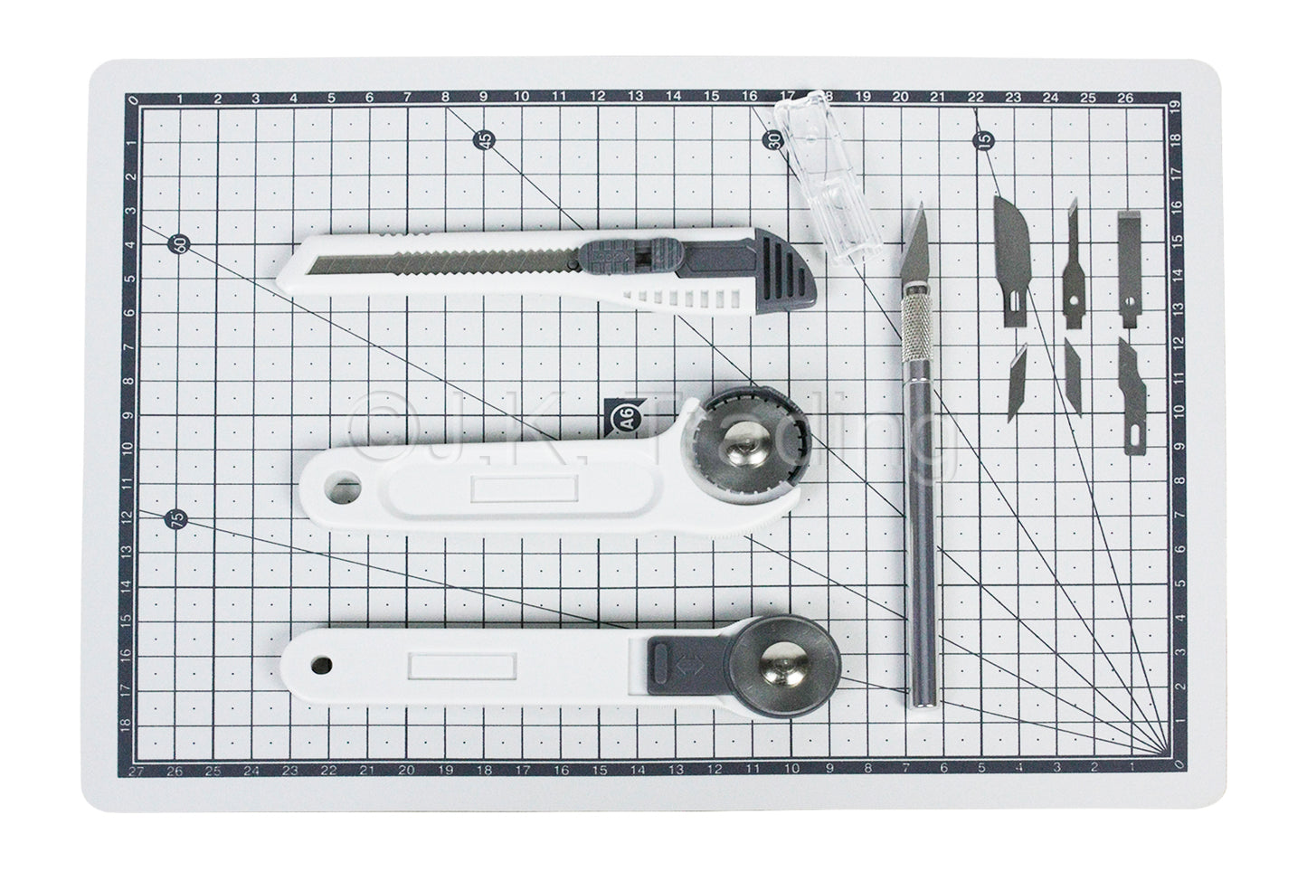 5-piece precision craft tool kit neatly arranged with a carving knife set, steel rule, and a gridded protective workbench pad.