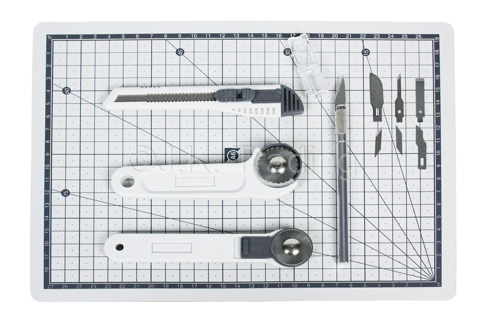 5-piece precision craft tool kit neatly arranged with a carving knife set, steel rule, and a gridded protective workbench pad.
