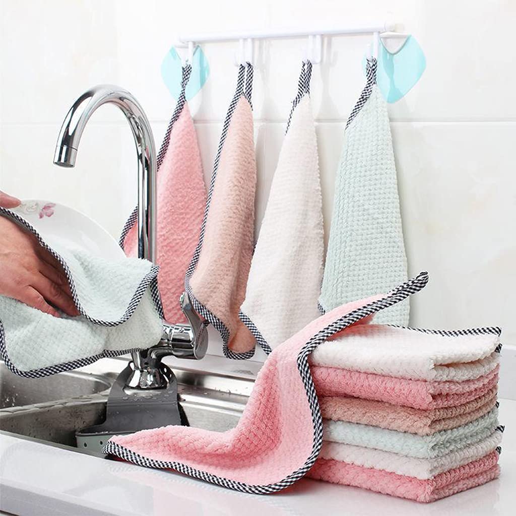 Stack of colorful kitchen towels hanging over a sink with a hand towel draped over the faucet.