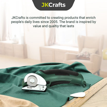Brand lifestyle graphic showcasing the green electric craft scissors resting on smooth folded silk fabric.