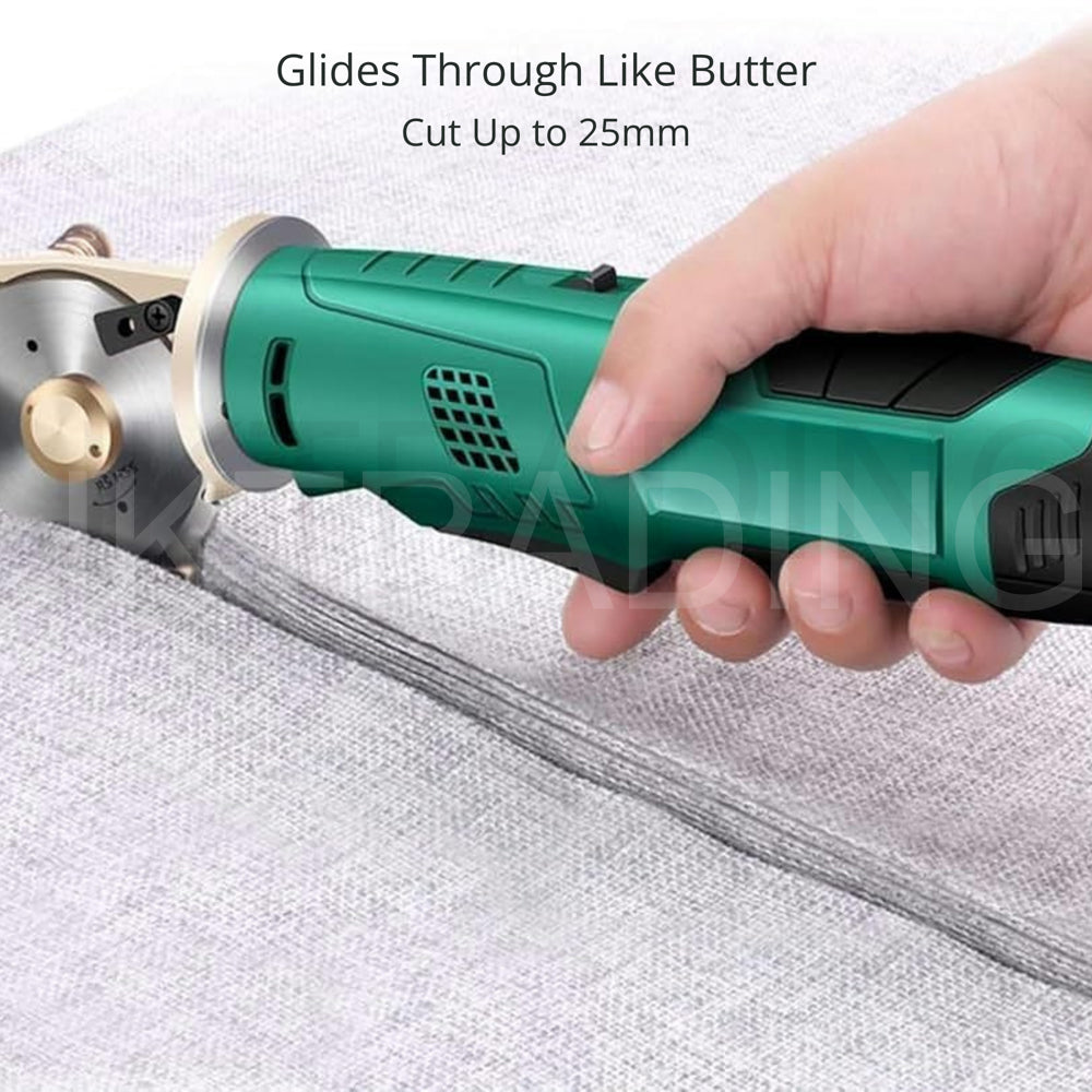 Hand-held cordless rotary shear smoothly slicing through thick grey wool carpet material up to 25mm deep.