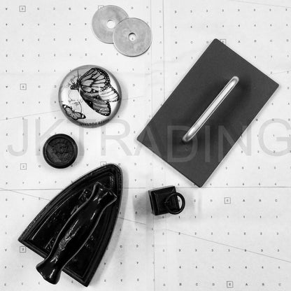Assorted metal and cast iron sewing studio tools including pattern weights, metal washers, and a cutting mat grid.