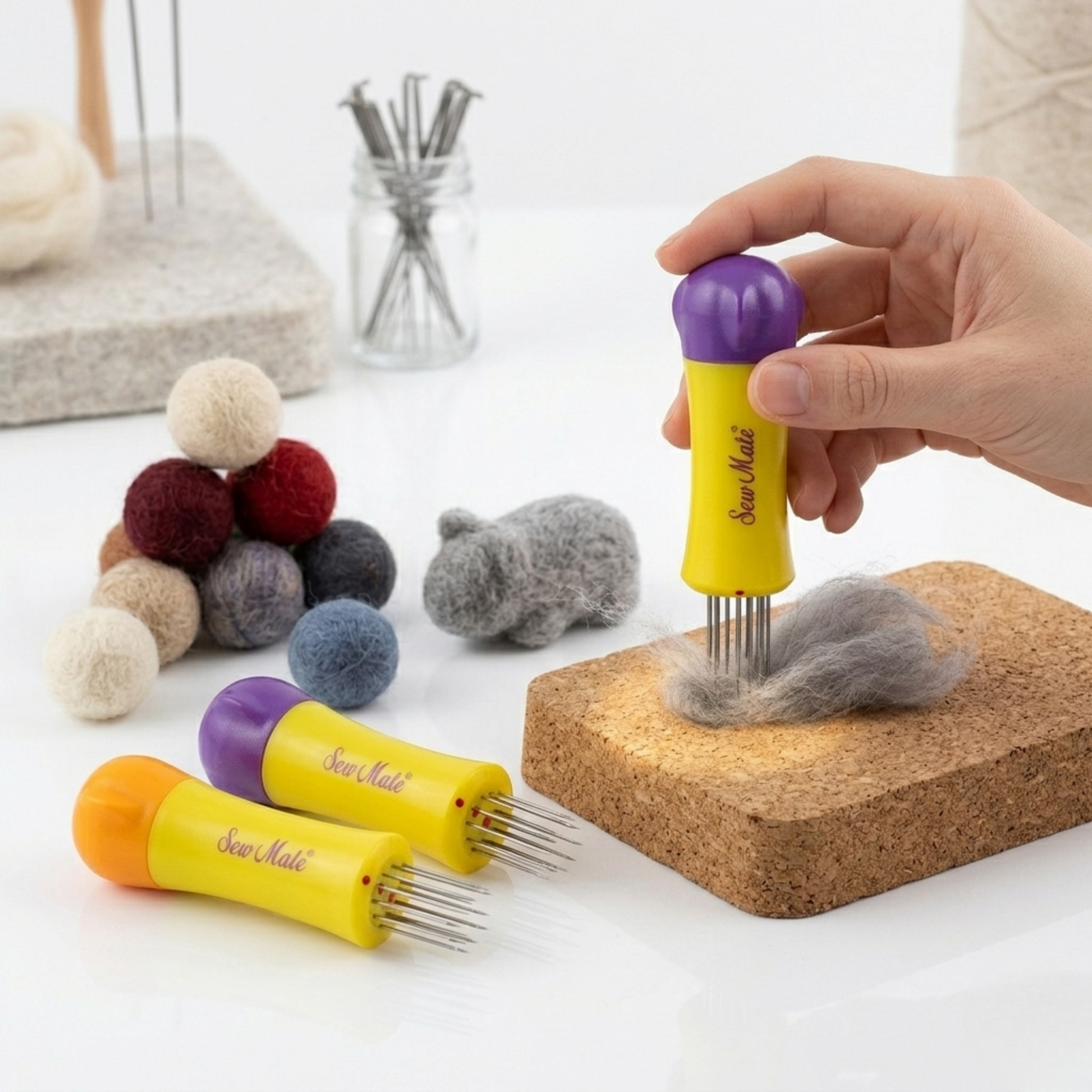 Crafter punching grey wool fiber on a cork block surrounded by colorful needle-felted wool balls.