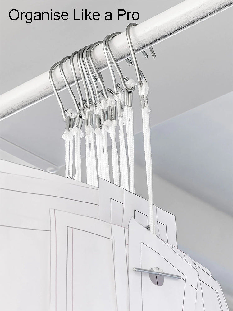 Multiple master paper patterns neatly organized on a rolling apparel rail using white nylon pattern hooks.