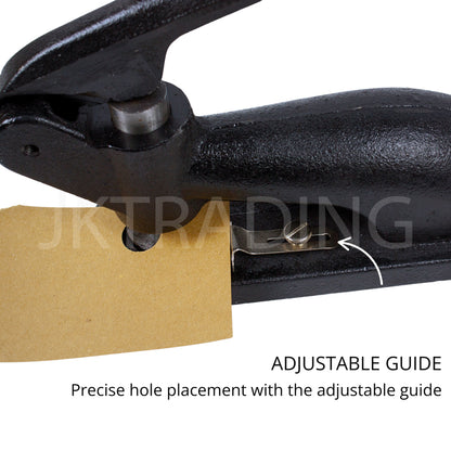 Black hole puncher with adjustable guide holding a piece of cardboard, branded 'JK Trading'.