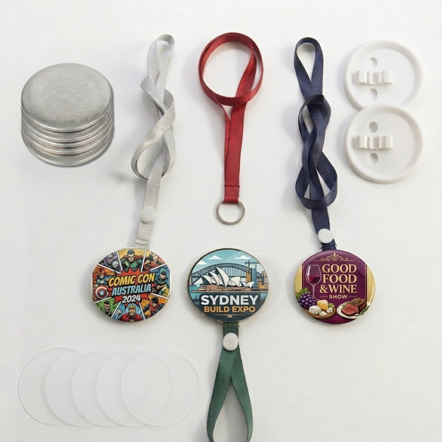Assorted JKCrafts lanyard button badges in red, blue, green, and silver with custom printed graphic designs.