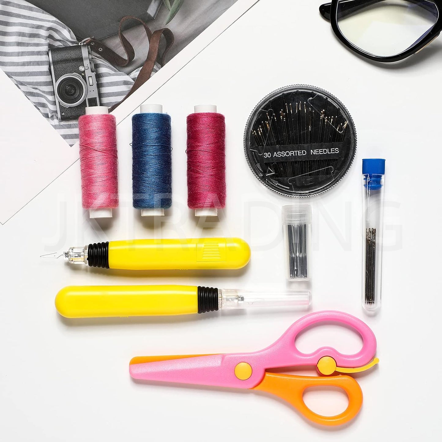 Full portable sewing kit layout including the yellow lighted threader, safety scissors, multi-color thread spools, and a needle wheel compact.