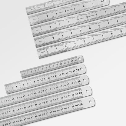 Sorted stack of durable metal workshop rulers ranging from small pocket sizes to large drafting sizes.