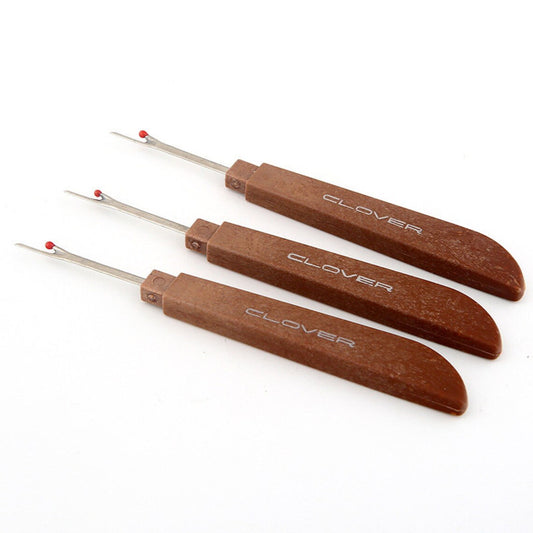 Three professional seam rippers featuring ergonomic wood-grain handles fanned out on a white background.