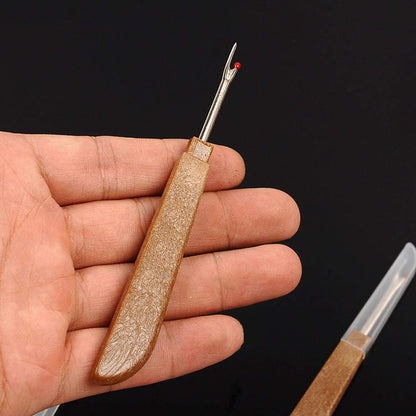 Hand holding a lightweight wood-style handle thread unpicker tool to showcase comfort and scale.