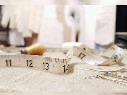 Measuring tape and sewing tools on a fabric surface with a blurred background