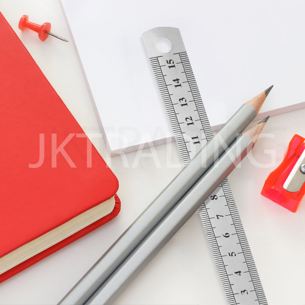 Architectural drafting workspace setup with a steel ruler, grey pencil, red notebook, and a sharpener.