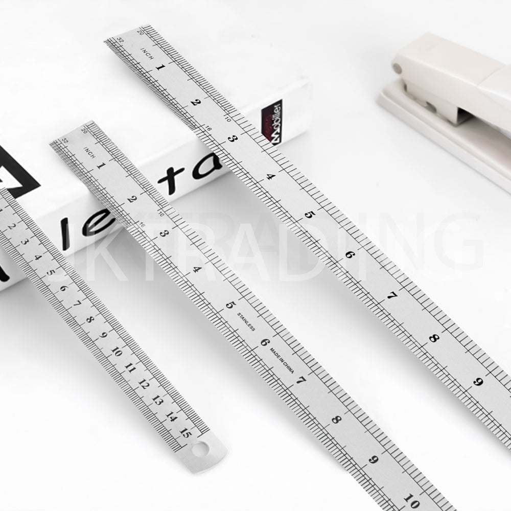 Metal scale rulers laid out next to engineering tools and office stationery items on a desk.