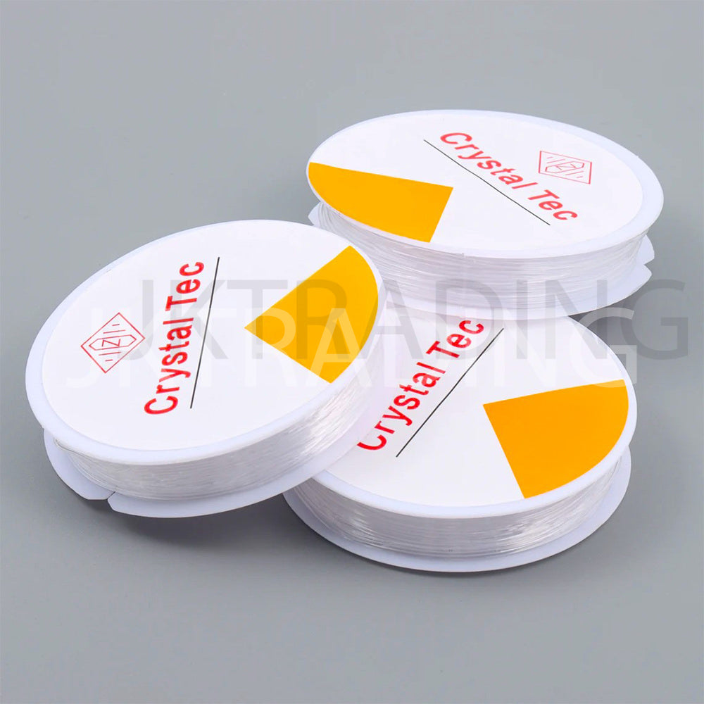 Three spools of Crystal Tec fishing line on a gray background