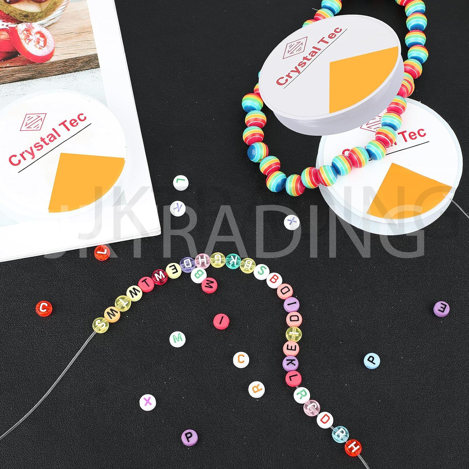 Colorful beaded necklaces with letter beads on a black surface, featuring 'Crystal Tec' packaging.