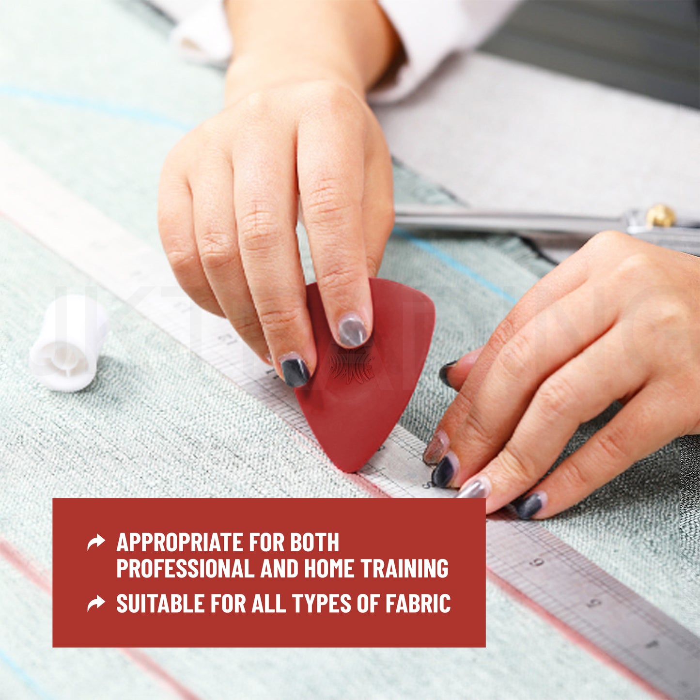 Dressmaker using a red triangle chalk marker to draft precise pattern lines along an acrylic ruler on blue fabric.