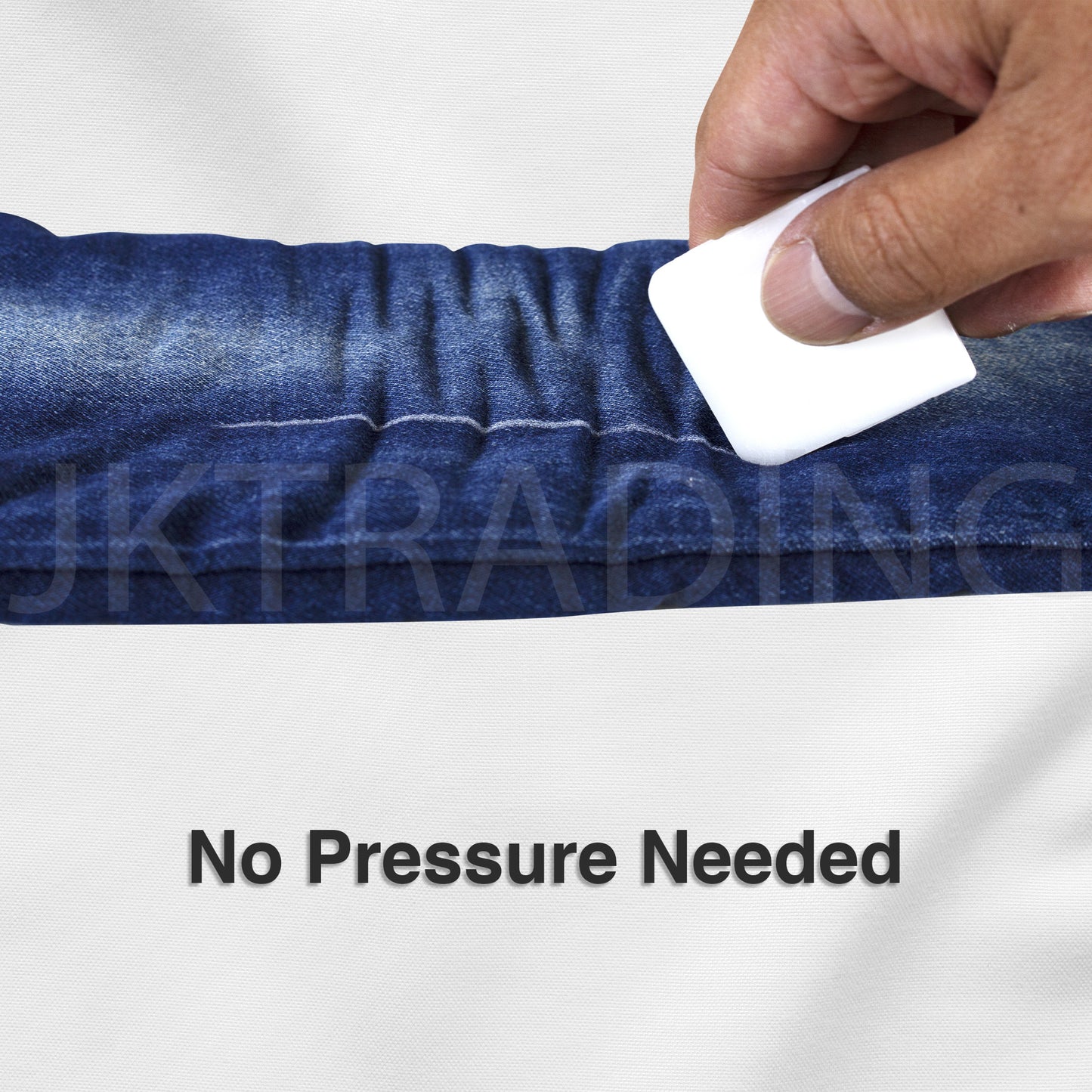 Hand holding a disappearing sewing wax block to lightly mark dark denim fabric without requiring downward pressure.