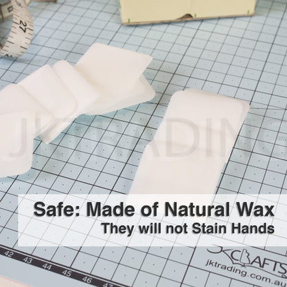 Non-staining square natural wax fabric markers arranged flat on a green professional cutting mat.