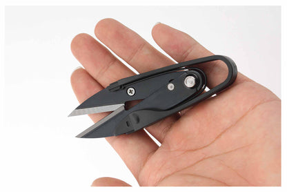 Single black pocket embroidery yarn cutter resting flat in an open hand to showcase its ultra-lightweight portability.