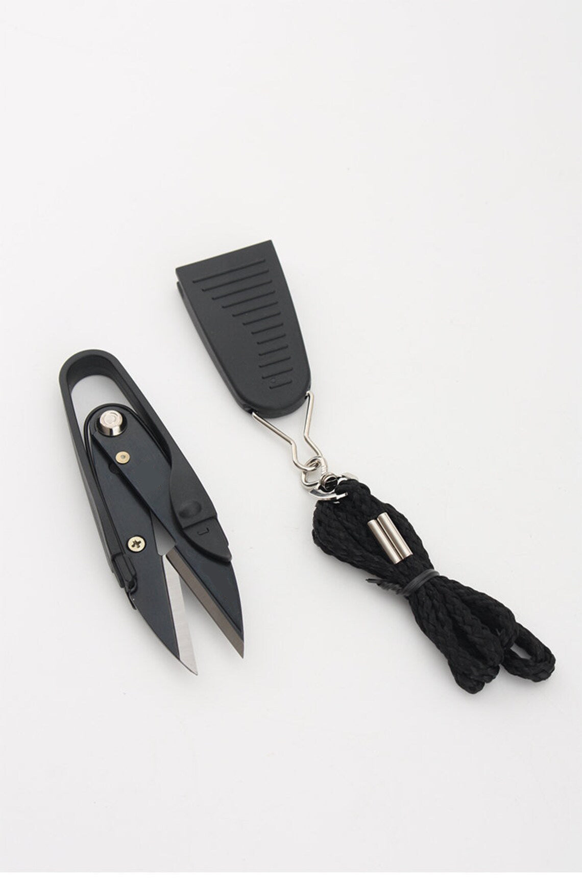 Minimalist product layout featuring the professional black thread nipper tool, its protective cap, and the lanyard cord.